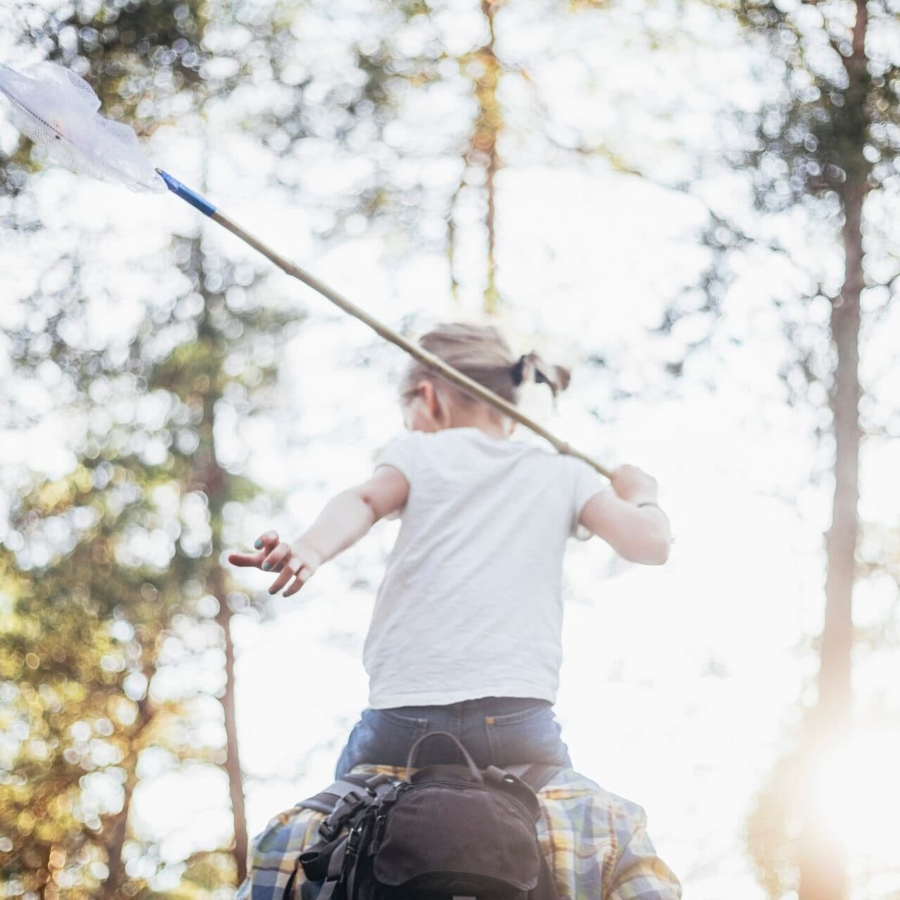 Flicka med en håv i skogen.
