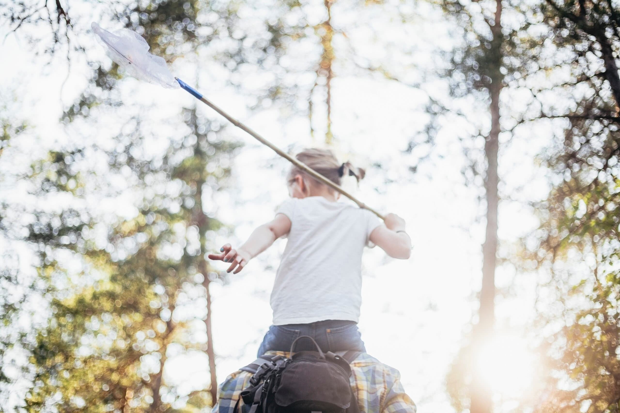 Flicka med en håv i skogen.