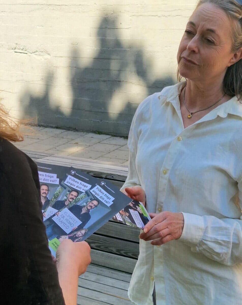 Två personer som prata med varandra och där en person dela ut material till den annan.