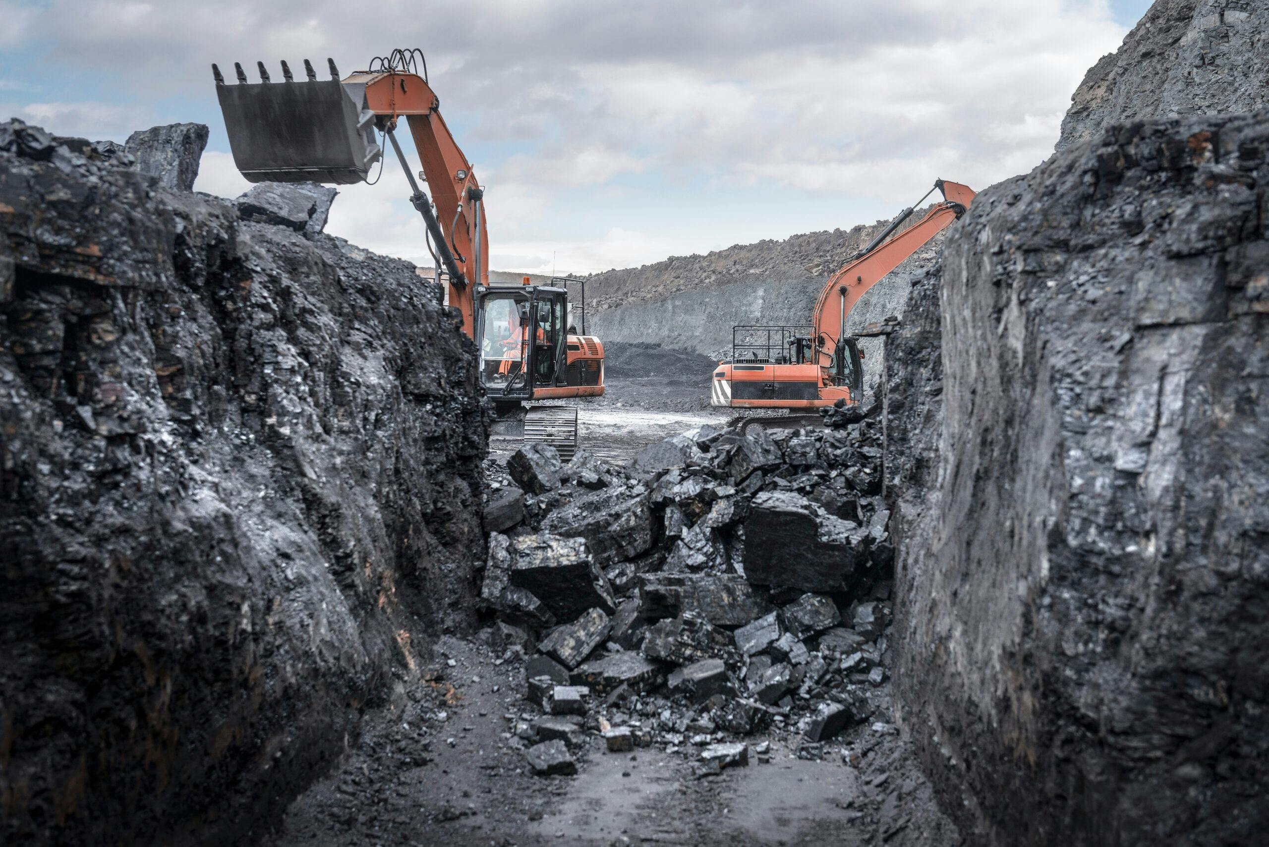 Grävmaskiner gräver ut kol.