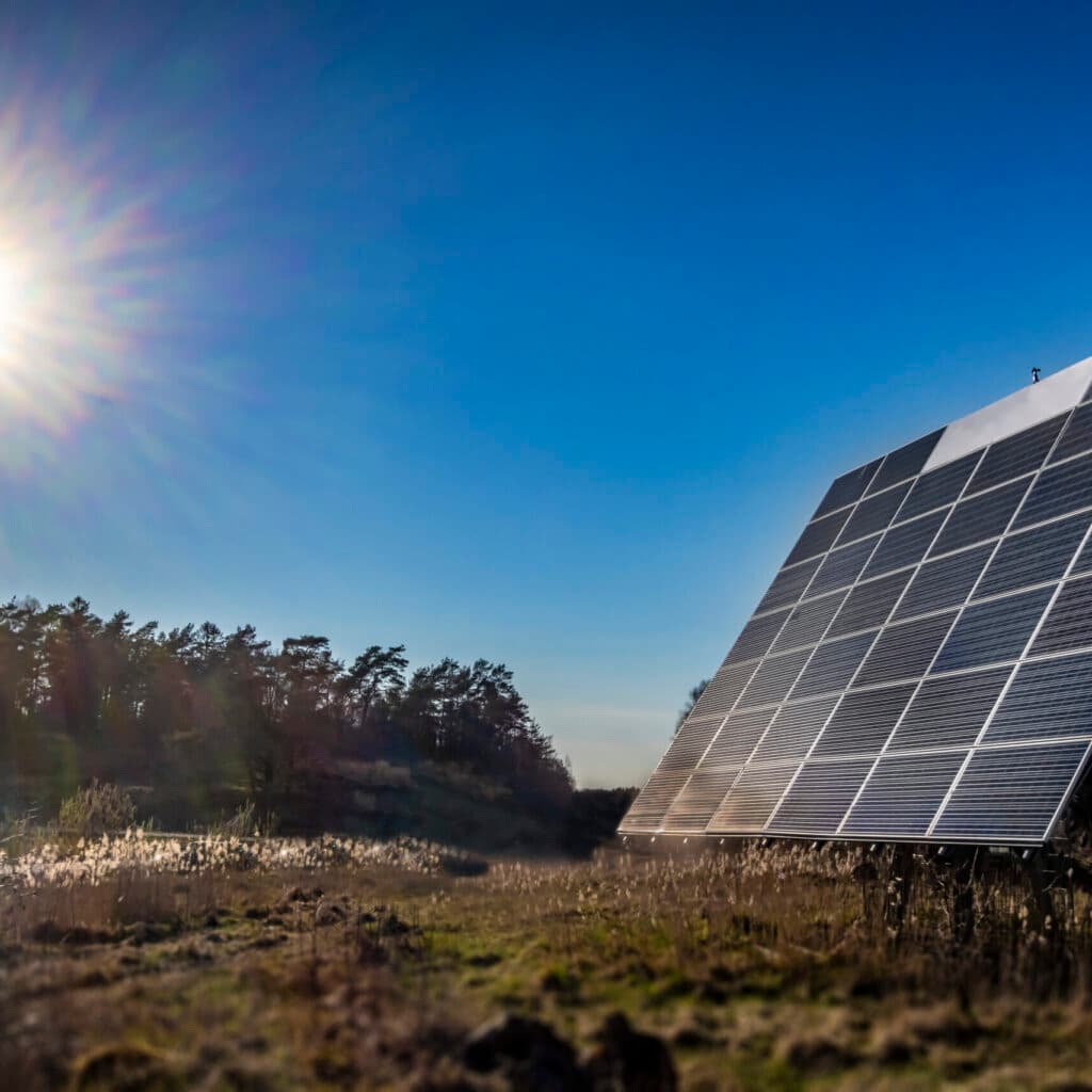 solceller i ett öppet landskap med solen synlig på himlen. Bilden används i en artikel om solenergi ...