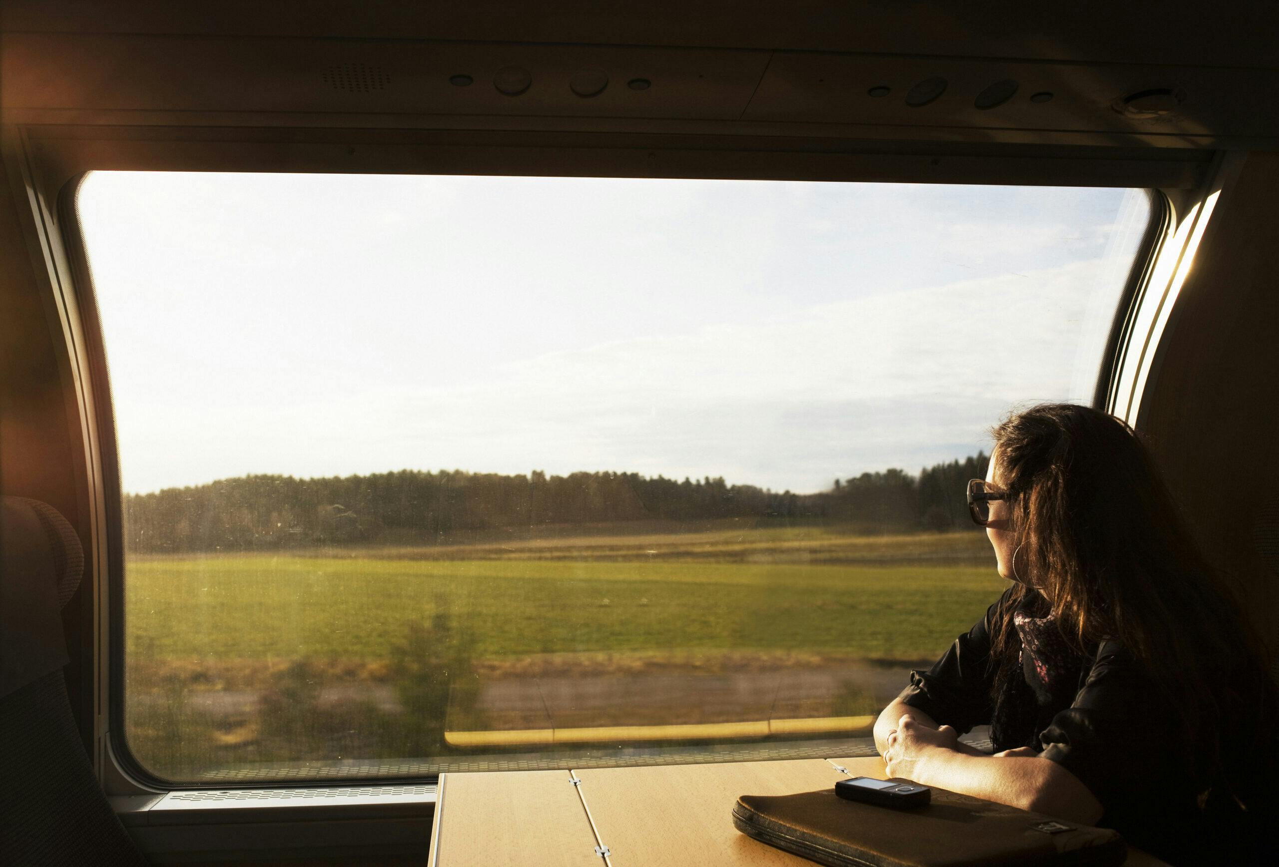 scandinavia, sweden, color image, commute, commuter, copy space, day, head and shoulders, horizontal, journey, landscape, leisure, lifestyle, look out, mid adult, one mid adult woman only, one person only, passenger, photography, relaxing, ride, side view, train, vehicle interior, window, tågfönster, tåg, tågresa, resa, kvinna på tåg,