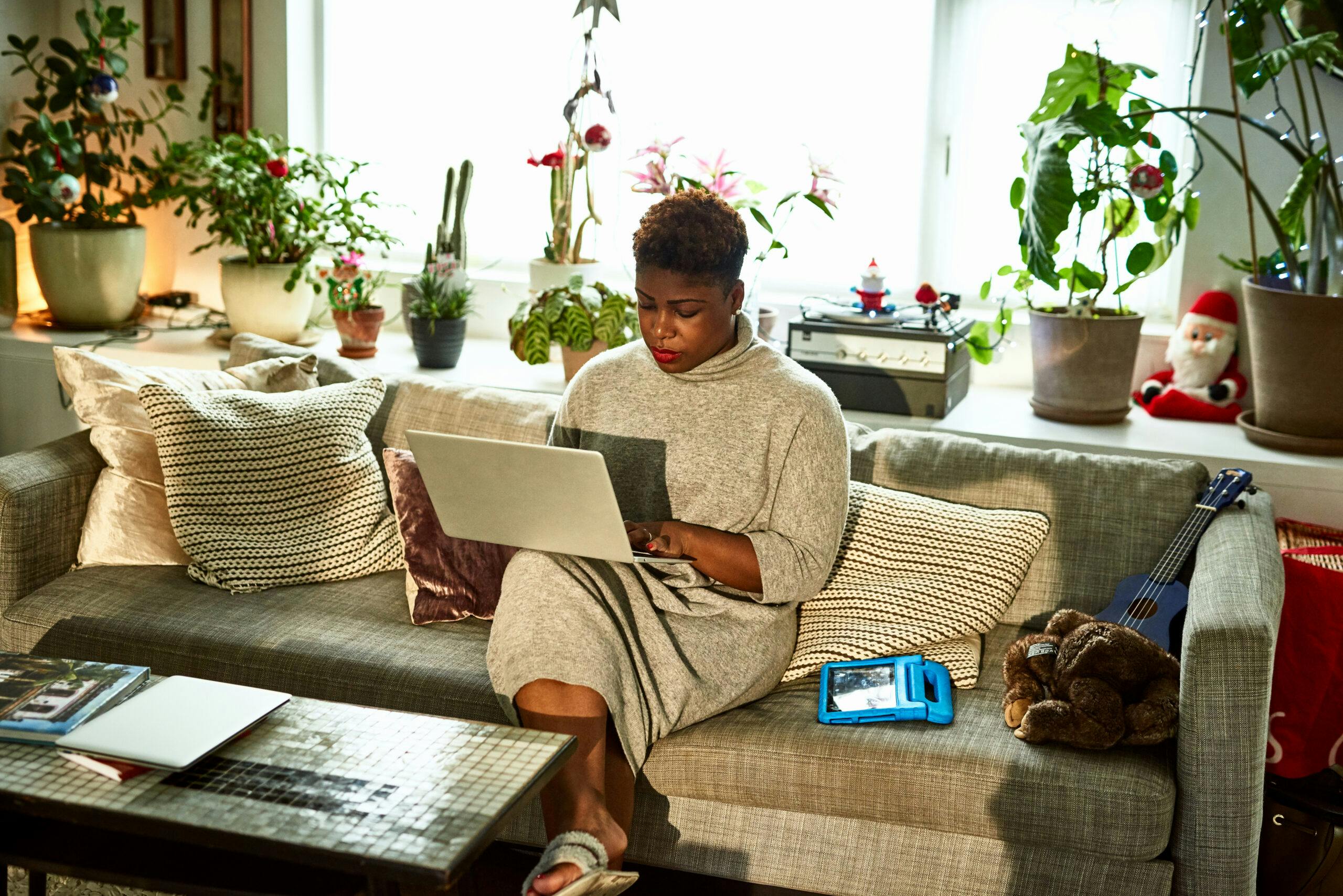 Kvinna sitter med dator i knät. Bli digital aktivist från soffan.