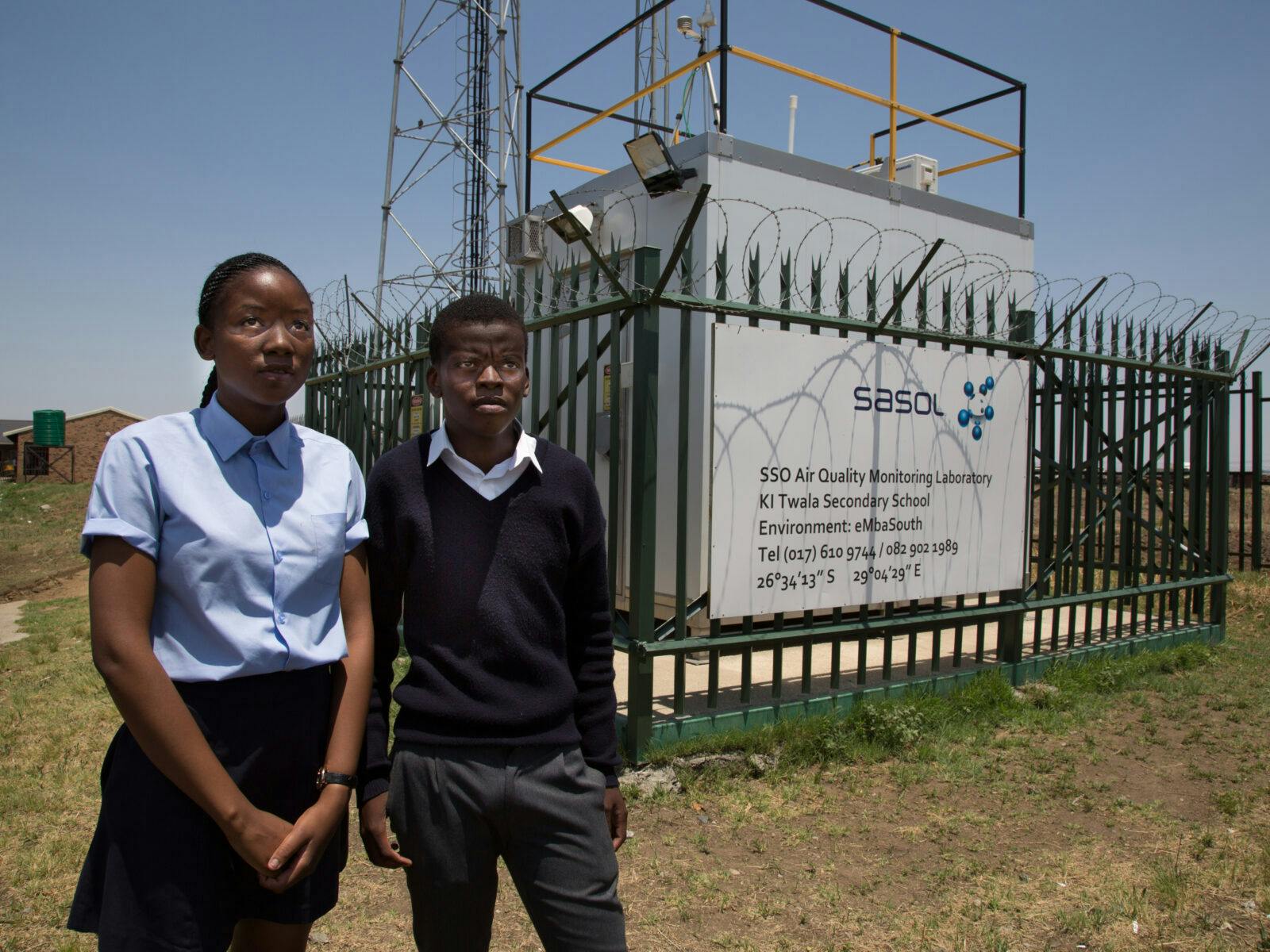 Eleverna Khensani Shabangu , 15, och Salva Sunguza, 19, framför kolanläggningens luftmätningsstation.