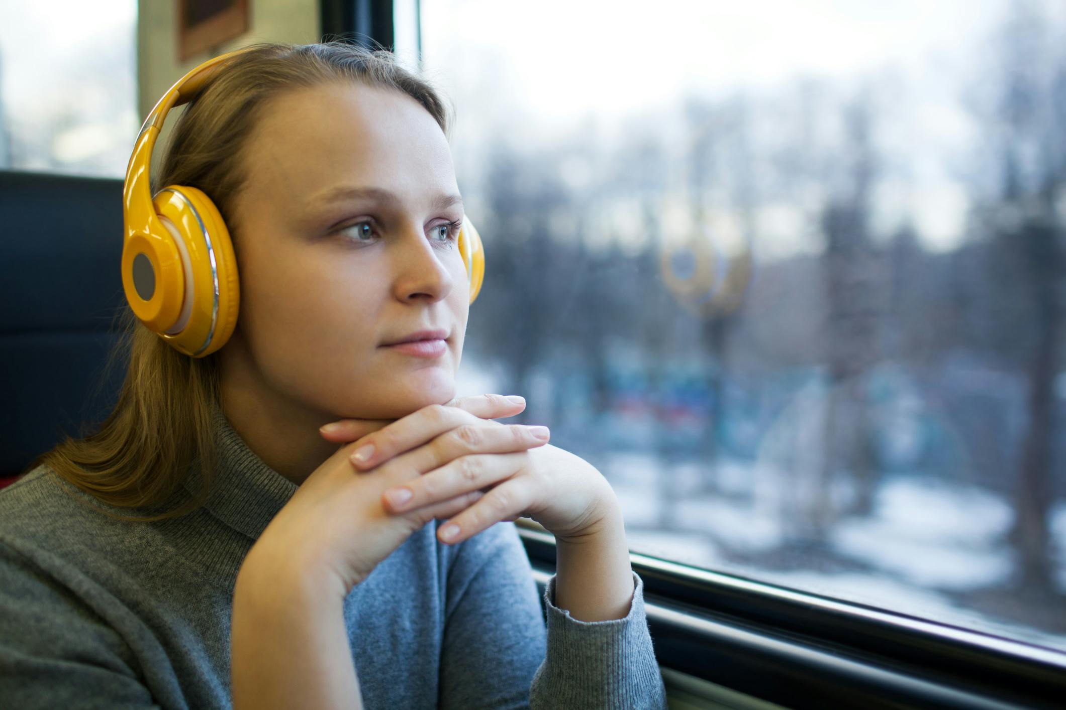 Ung kvinna ser ut genom tågfönster.