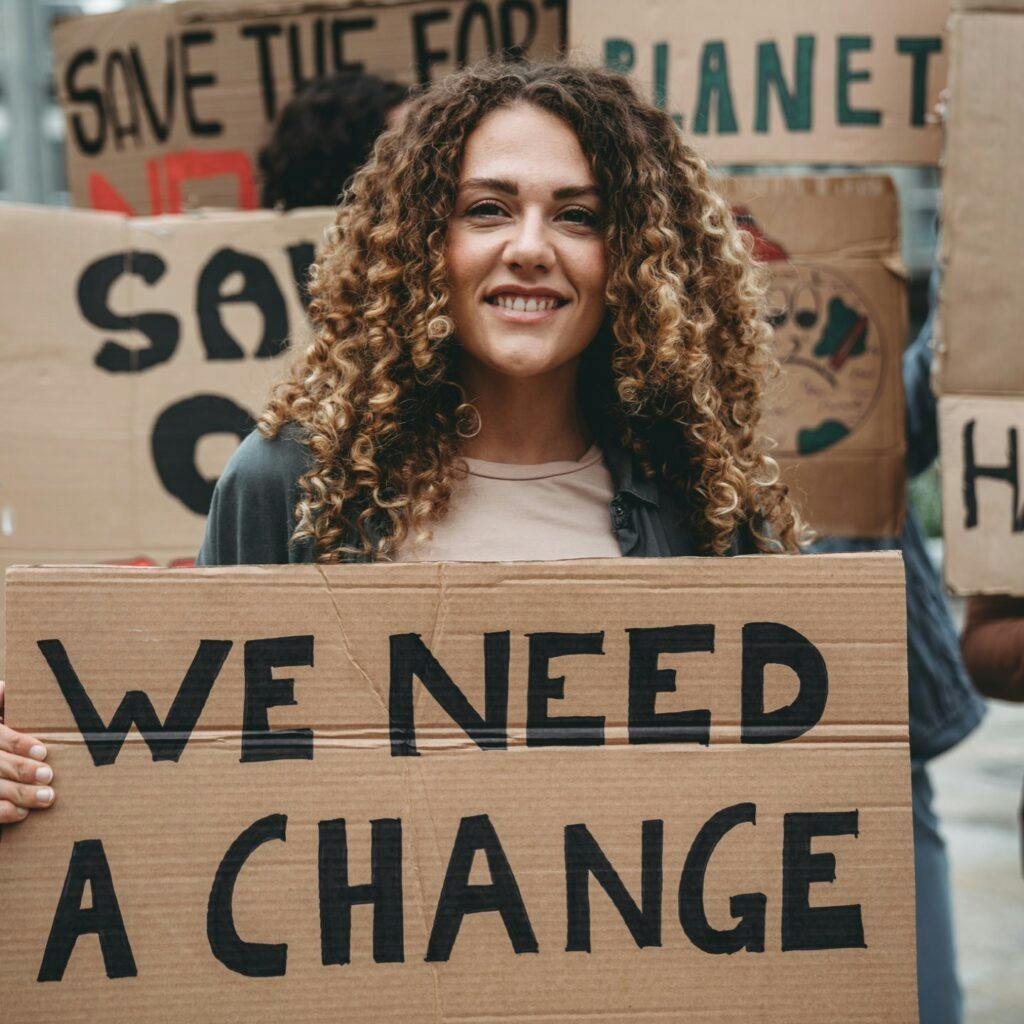 En grupp människor demonstrerar mot klimatförändringar. De håller i plakat. Rädda vår planet.