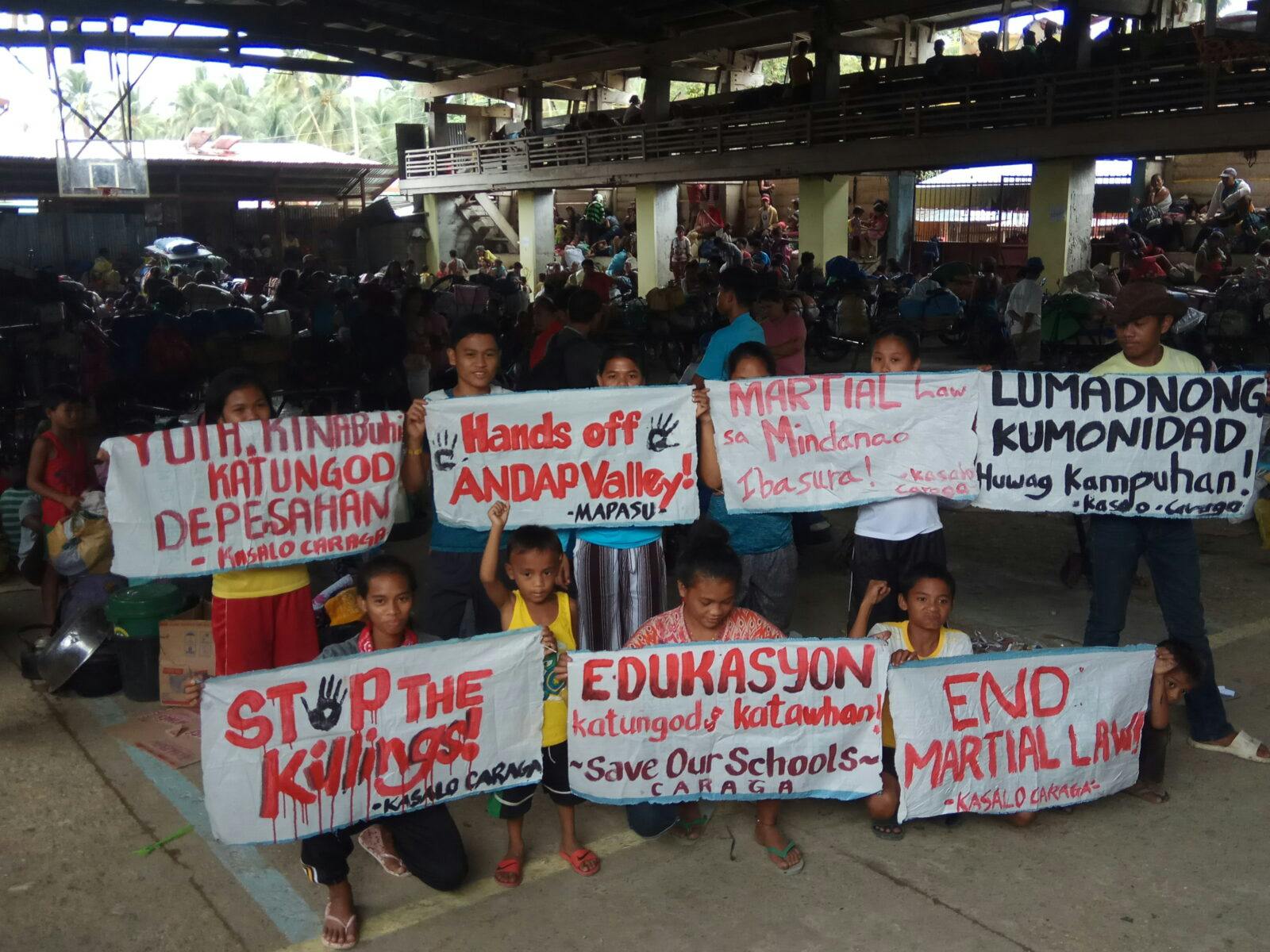 Lärare och elever vid ALCADEV byskola i Mindanao, Filippinerna, protesterar mot den senaste vågen av mord på lärare och miljöförsvarare