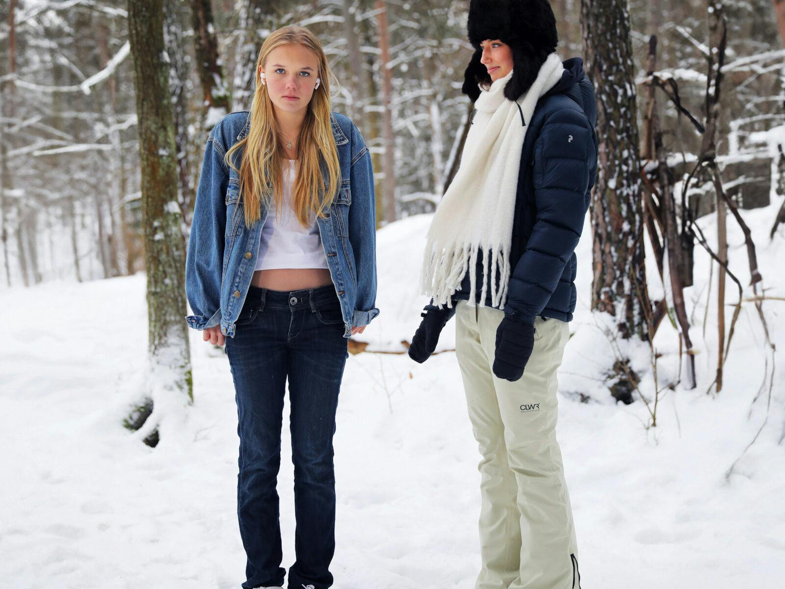 Två tjejer med olika kläder på vintern.