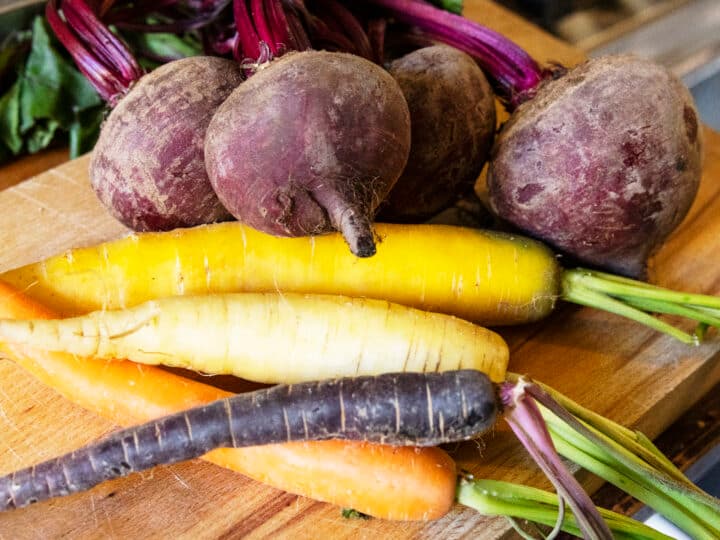 Yellow carrots and beetroots on a wooden board