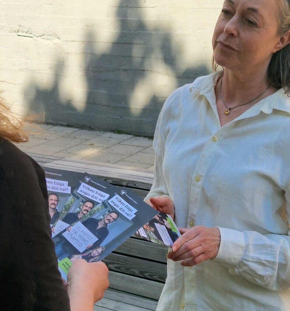 Två personer som prata med varandra och där en person dela ut material till den annan.